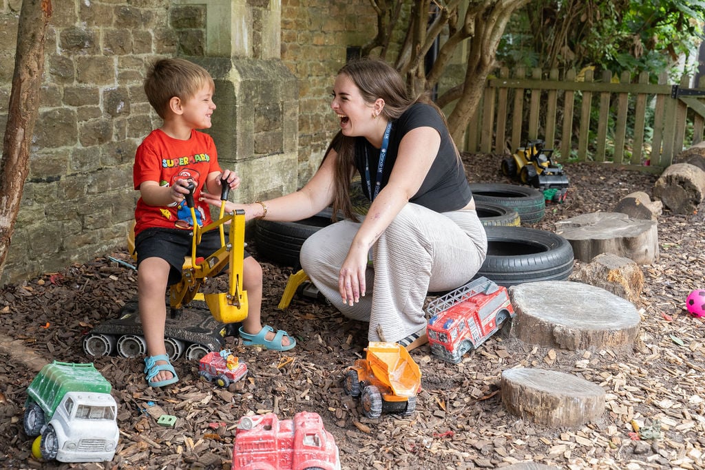 A woman and a child happily playing with colourful toys in a sunny playground