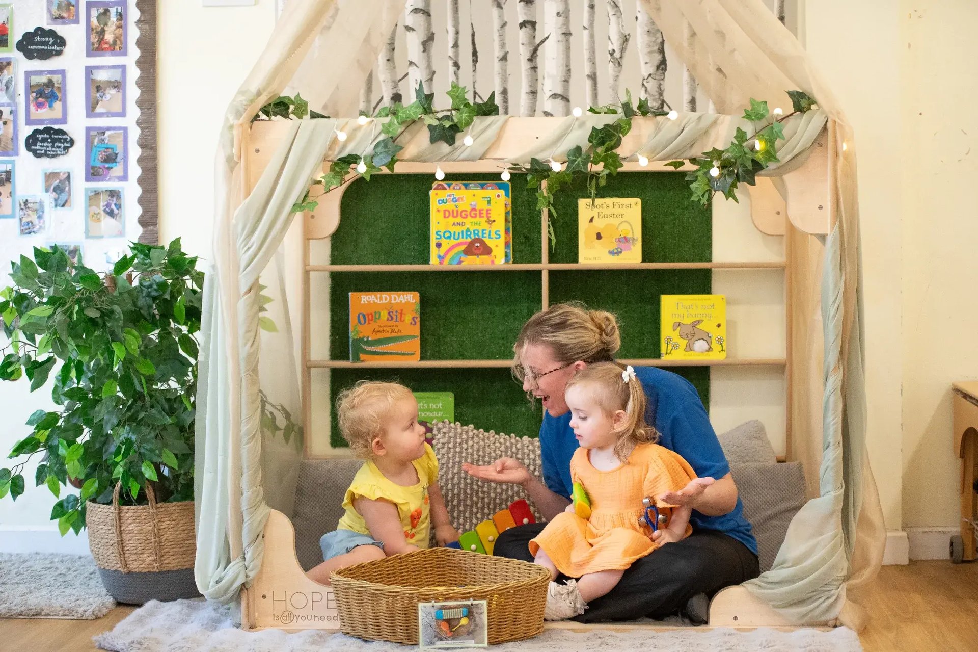 children-sitting-in-book-corner-with-key-worker-at-kiddi-caru-day-nursery-preschool-whiteley-2000x1333