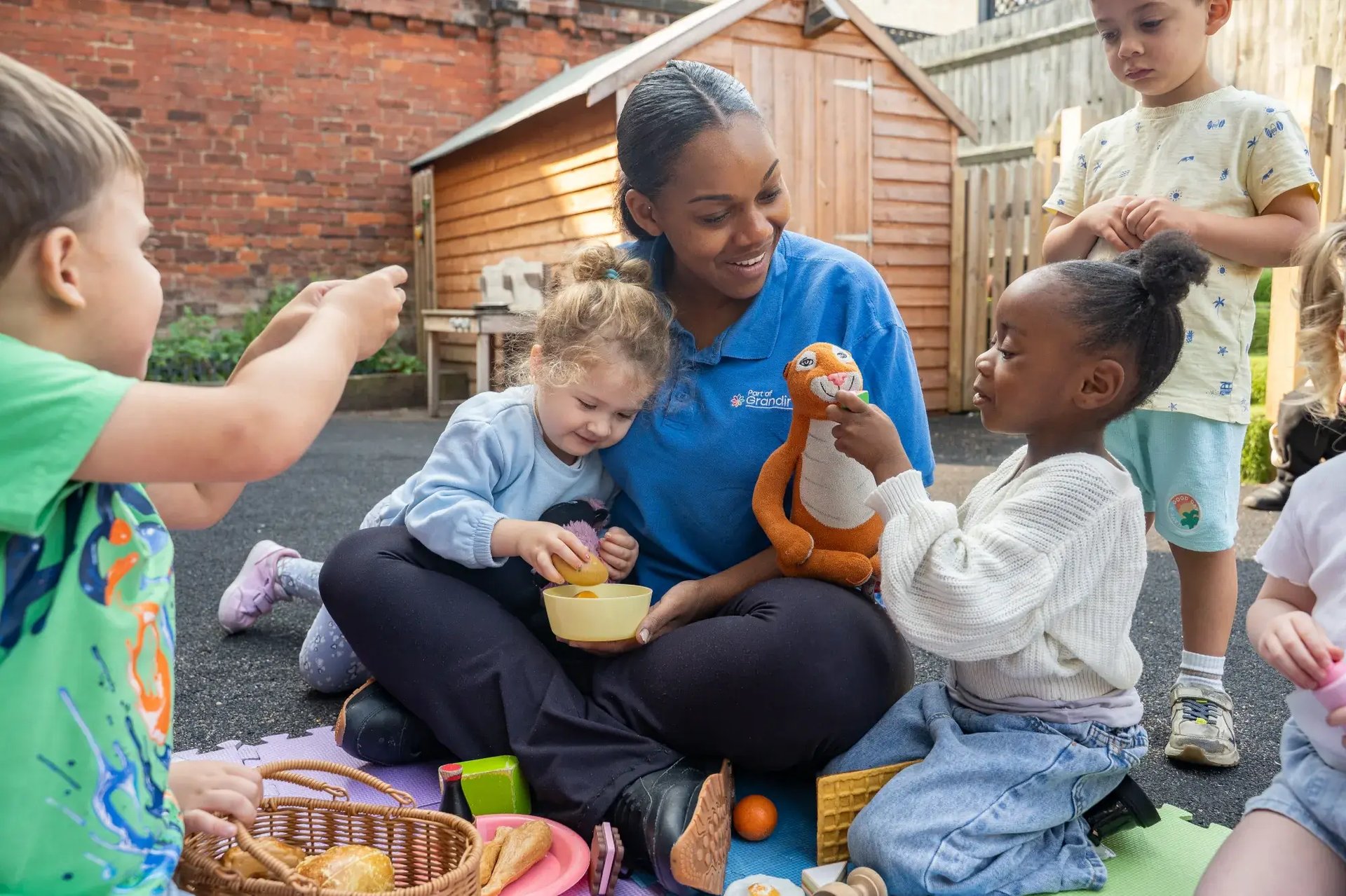 key-worker-playing-in-garden-with-children-at-the-anerley-day-nursery-preschool-london-2000x1333