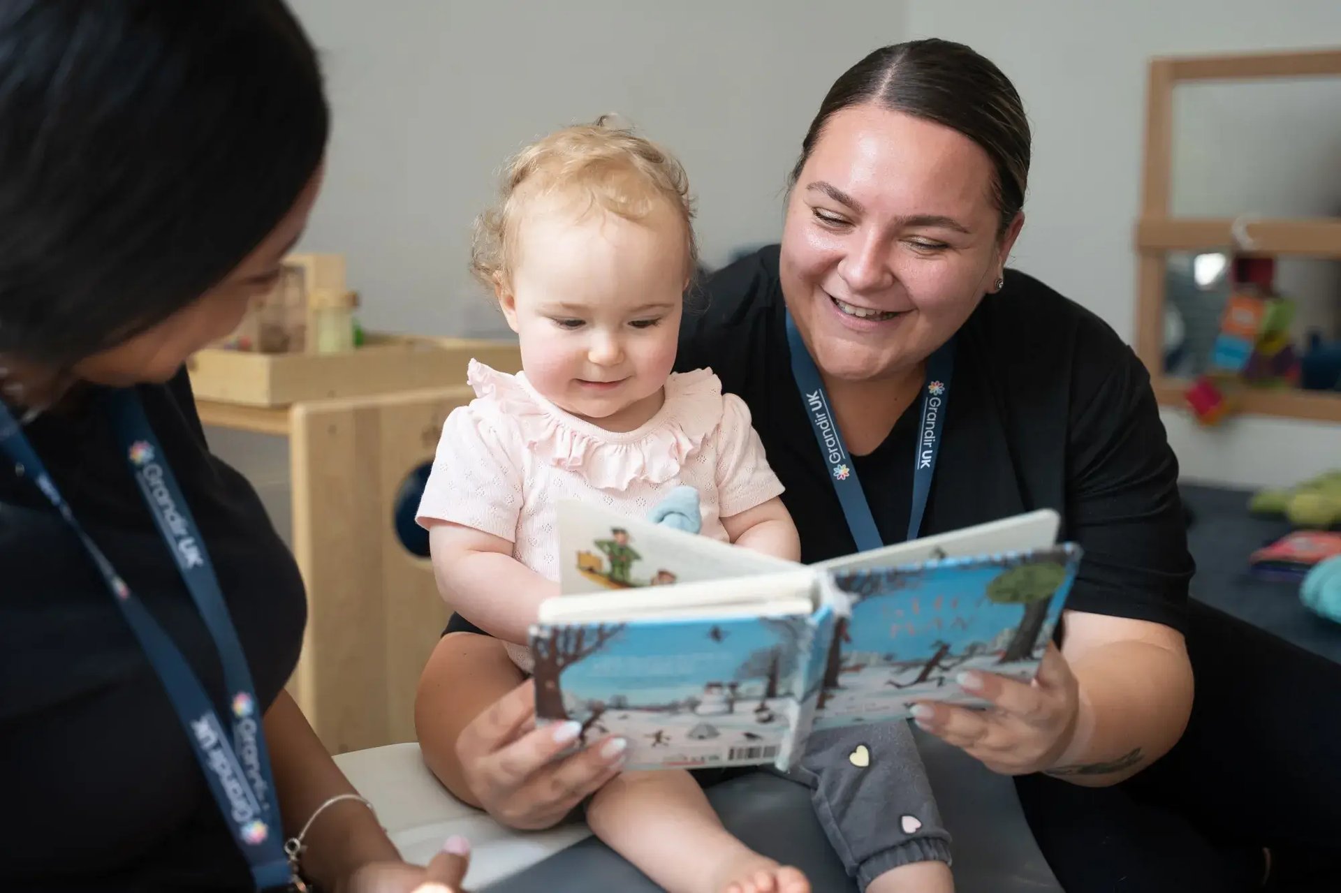 key-workers-reading-book-with-child-at-the-crystal-palace-day-nursery-preschool-london-2000x1333